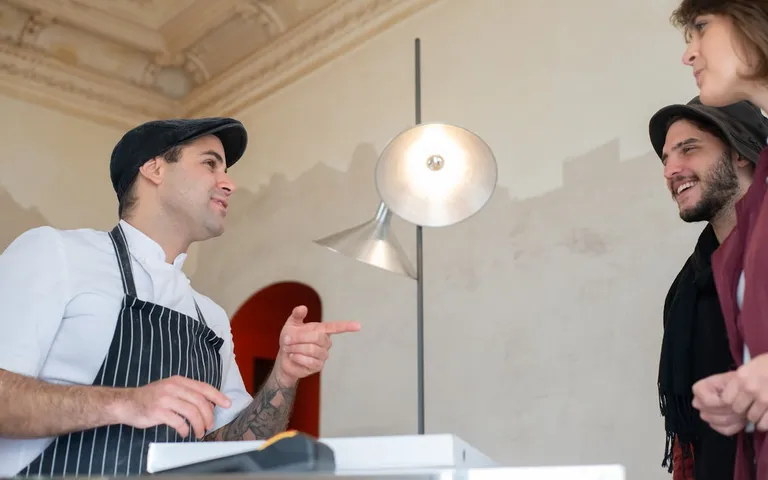 Chef chatting with happy customers in a restaurant