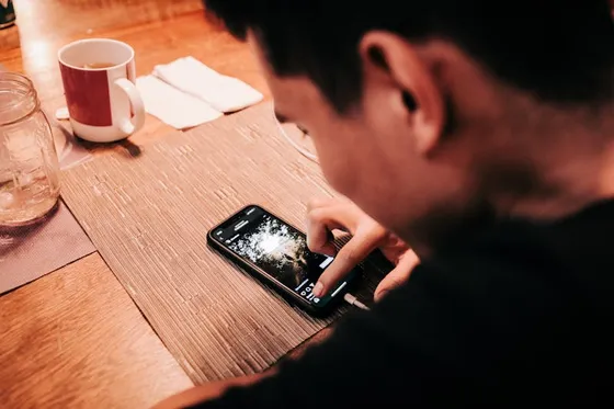 Person checking phone at a warm-lit table
