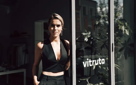 Young business owner standing confidently at the door of her store
